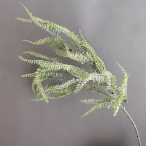 Close-up detail of artificial flocked fern branch with realistic green leaves for decor.