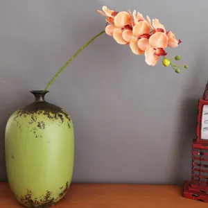 Künstliche Phalaenopsis Orchidee in grüner Keramikvase für moderne Heimdekoration und Hochzeit.