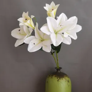 Bouquet di fiori di giglio bianco artificiale con vaso verde per arredamento e fotografia.