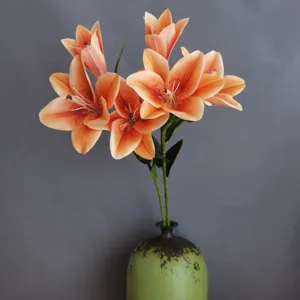 Bouquet di fiori di giglio artificiali arancioni in vaso di ceramica per decorazioni d'interni.