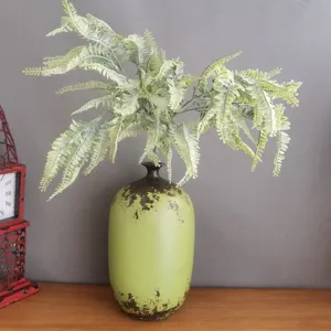 Artificial flocked Boston fern leaf stem with vintage green ceramic vase for home decor.
