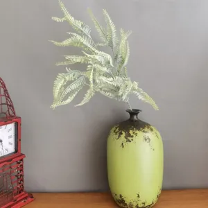 Detailed view of artificial flocked fern leaf in green ceramic vase for Nordic home decor.