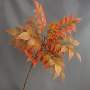 Vista detallada de rama de hojas de otoño artificiales con follaje naranja brillante para decoración.