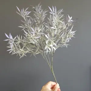 Close up detail of artificial flocked foliage branch with five forks for floral decor design.