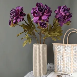 Bouquet di fiori di peonia artificiali in vaso di ceramica bianca per decorazioni domestiche.