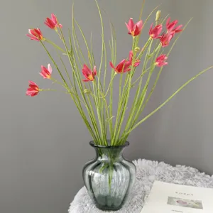 Artificial flower detail shot, pink blooms in green glass vase on fluffy mat, home decor.