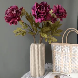 Dettaglio fiore peonia finta, vaso in ceramica bianca, elegante allestimento casa.