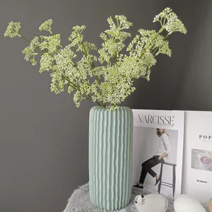 Primer plano detallado de la rama de flores de bayas artificiales y florero de cerámica.