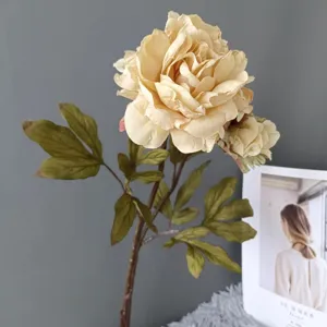 Primo piano dettagliato di peonia artificiale retro a due teste con foglie verdi.