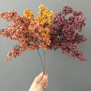 Dettaglio ramo di bacche artificiali, steli di frutta in schiuma colorata per decorazioni floreali.