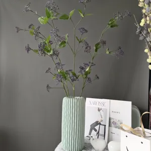 Künstliche lilafarbene Beeren-Zweige mit hellgrüner Keramikvase, ideal für elegante Deko.