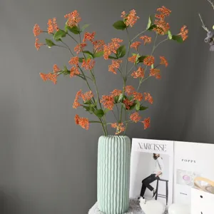 Künstliche orange Beerenzweige in mintgrüner Keramikvase, exquisite Detailansicht.