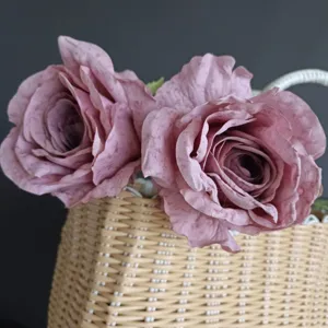 Primer plano detallado de rosas artificiales estilo vintage en cesta tejida para decoración.