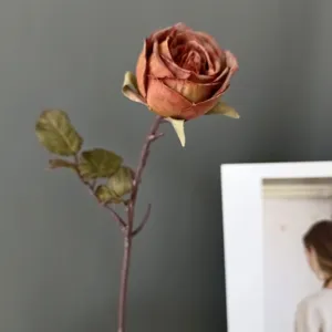 Primer plano detalle de rosa artificial vintage con tallo, flor elegante para decoración.