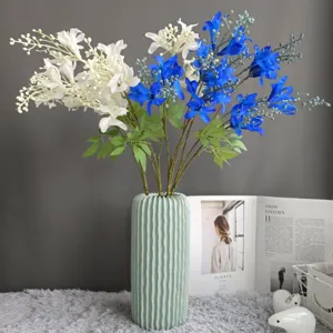 Artificial blue and white silk flowers with green ceramic vase for home decoration details.