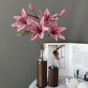 Artificial pink lily flowers in leather wrapped glass vase for home decor and wedding arrangement.