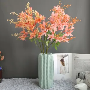 Detailed shot of artificial bamboo flowers in a mint green ceramic vase for home decor.