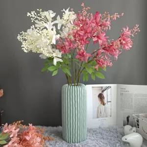 Detail view of artificial flower arrangement in mint green textured vase for home decor.