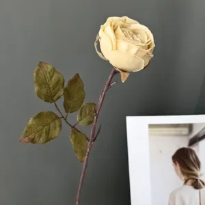Primer plano de una rama de rosa artificial vintage con capullo para decoración del hogar.