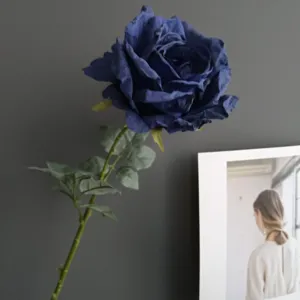 Primer plano detalle de rosa artificial azul oscuro, pétalos realistas y tallo decorativo.