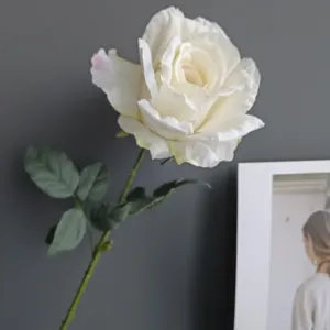 Detalle de rosa blanca artificial, flor falsa vintage con bordes quemados para decoración.