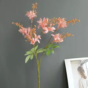 Close-up detail of artificial pink wild bamboo flowers with green leaves for home decoration.