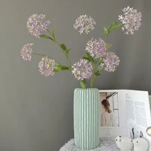Rama de hortensia artificial con florero de cerámica acanalado para detalles del hogar.