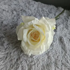 Detalle de flor de rosa artificial, rosa blanca falsa con bordes quemados para decoración hogar.