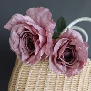 Primer plano de rosas artificiales rosas vintage con bordes quemados y pétalos enrollados a mano.