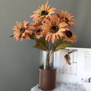 Bouquet di girasoli artificiali color pittura a olio con vaso in vetro e manica in pelle.