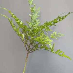 Dettaglio ravvicinato di foglia di felce artificiale, ramo di pianta in gomma per decori.