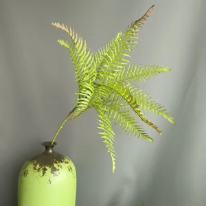 Artificial fern branch detail view, realistic soft-rubber plant for home decor and floral design.