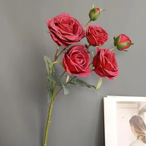 Detail of vintage artificial red roses with burnt edges, realistic petals and leaves.