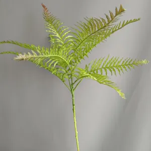 Artificial fern leaf detail shot, realistic soft rubber texture, green plant stem close-up.
