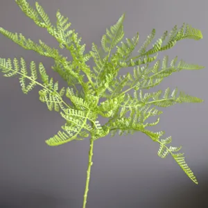 Artificial soft rubber fern single branch plant close up for modern nordic home decor display.