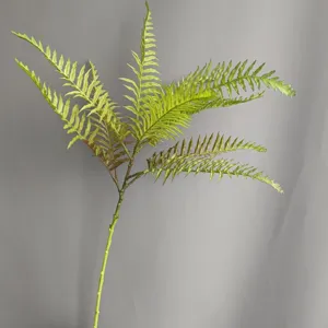 Detailed closeup of artificial Boston fern leaf branch, realistic soft rubber plant decor.