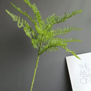 Close-up detail of artificial fern branch, realistic green foliage for home decor.
