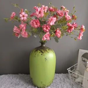 Artificial pink roses bouquet with vintage green ceramic vase for home decor wedding table.