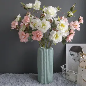 Artificial flower bouquet with pink and white roses in a ribbed green vase for home decor.