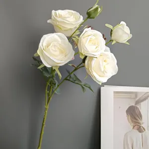 Detailed shot of artificial white roses with green stems, perfect for home decor display.