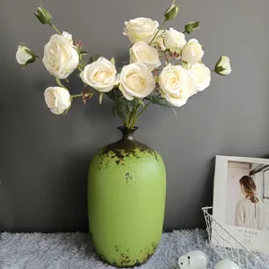 Nordic vintage green vase with artificial white roses for home decor and wedding party use.