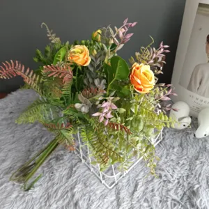 Bouquet de fleurs de roses orange artificielles avec feuilles de fougère, déco mariage nordique.
