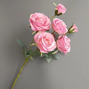 Artificial pink rose branch detail showing exquisite petal texture and realistic green leaves.