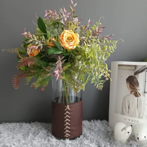 Bouquet de fleurs artificielles en vase en verre avec étui en cuir pour déco de mariage.