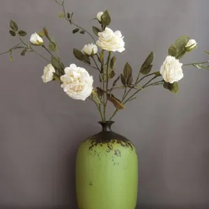 Künstliche weiße Rosen in Vintage grüne Keramikvase für Heimtextilien Fotografie Requisiten.