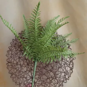 Primo piano dettagliato di foglie di felce artificiale, ramo di pianta morbida per decorazione.
