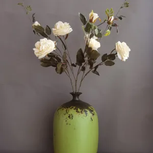 Elegantes künstliches Blumengesteck mit vintage grüner Keramikvase für die Heimdekoration.