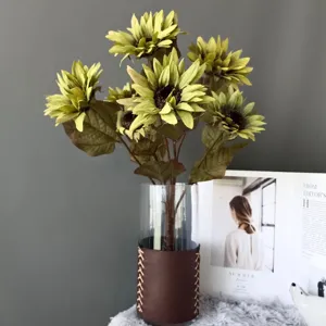 Primo piano di girasoli retro artificiali in vaso di pelle per decorazioni d'interni.