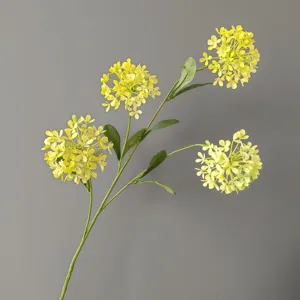 Detalle de rama de flor amarilla artificial, textura floral realista y diseño de tallo verde.
