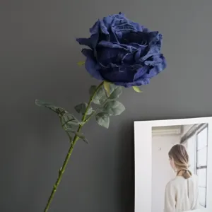 Primer plano detallado de una elegante rosa artificial azul oscuro con pétalos realistas.